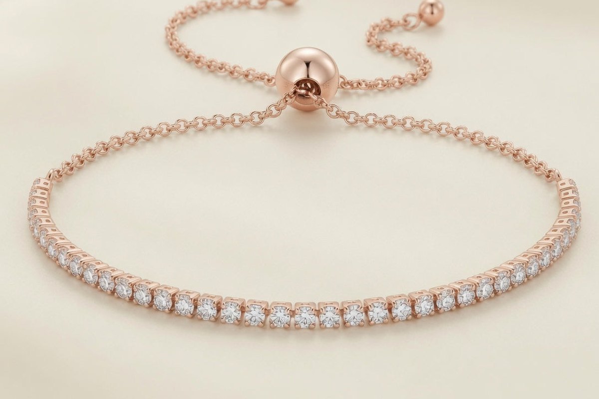 Bracelet Rivière de Lumière, finition dorée rose, ligne de zirconium cubique et fermoir bolo réglable, sur fond crème