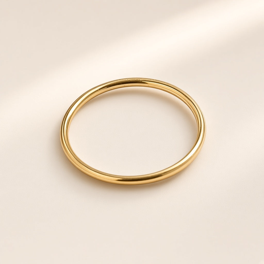 Bague Trait de Plume, finition dorée sur argent 925, anneau rond, lisse et très fin, sans pierre, sur fond crème