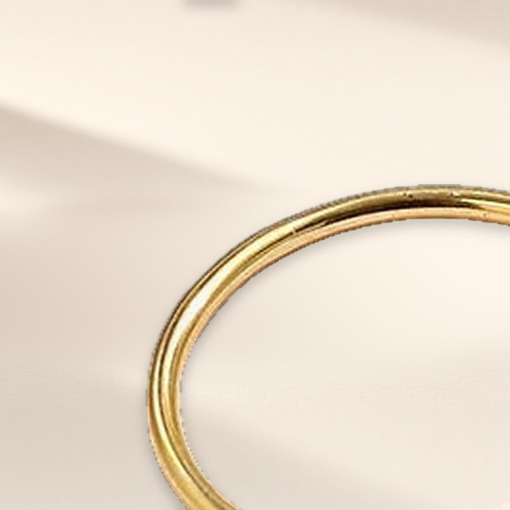 Bague Trait de Plume dorée en gros plan : l'anneau lisse et très fin
