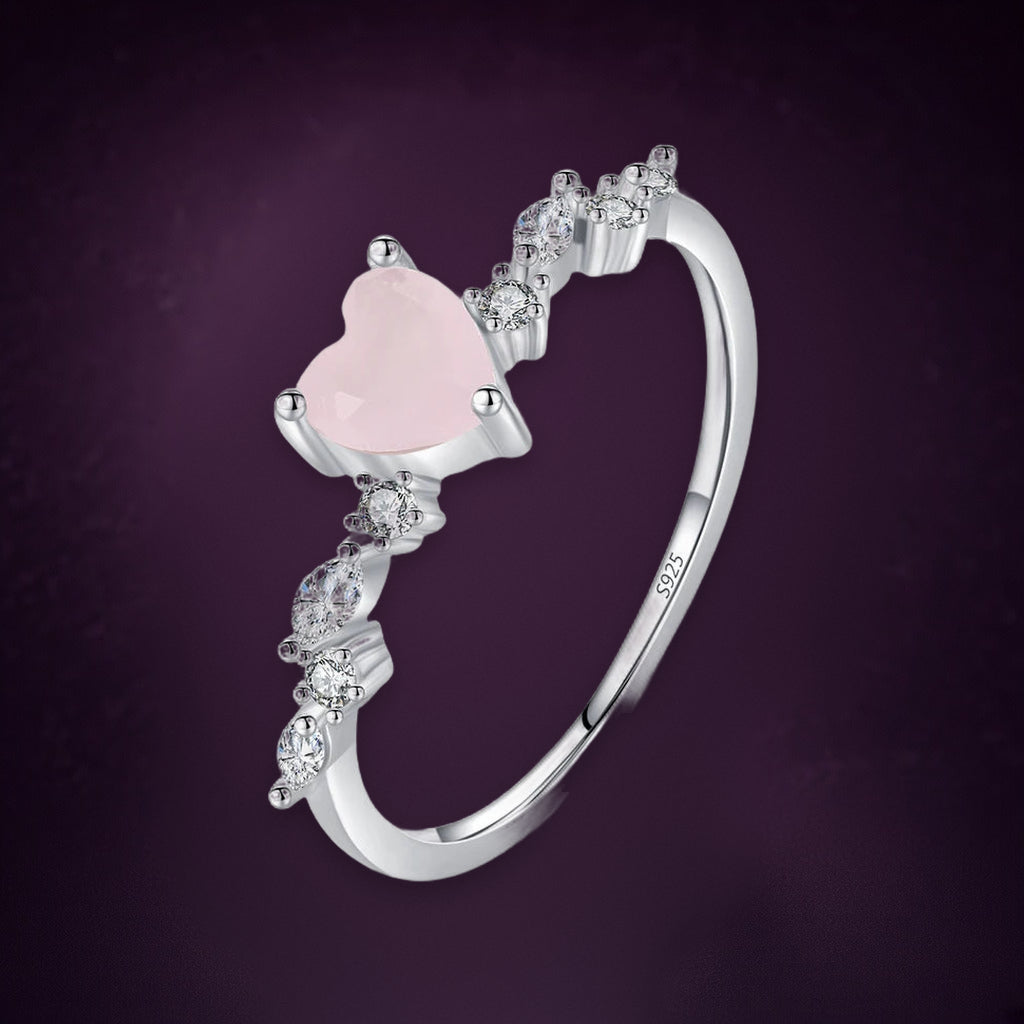 Bague Églantine vue de trois quarts : cœur rose pâle au bout d'une branche de petites pierres claires