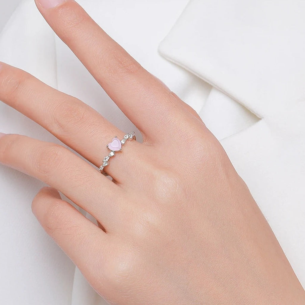 Bague Églantine portée au doigt : le petit cœur rose sur l'anneau fin