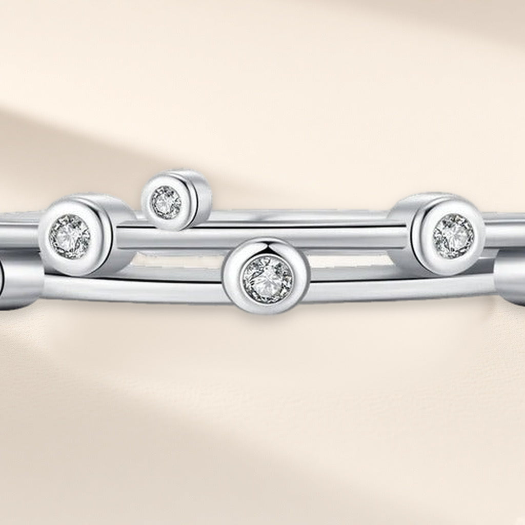Bague Deux Orbites en gros plan : double anneau fin semé de petites pierres claires en serti clos