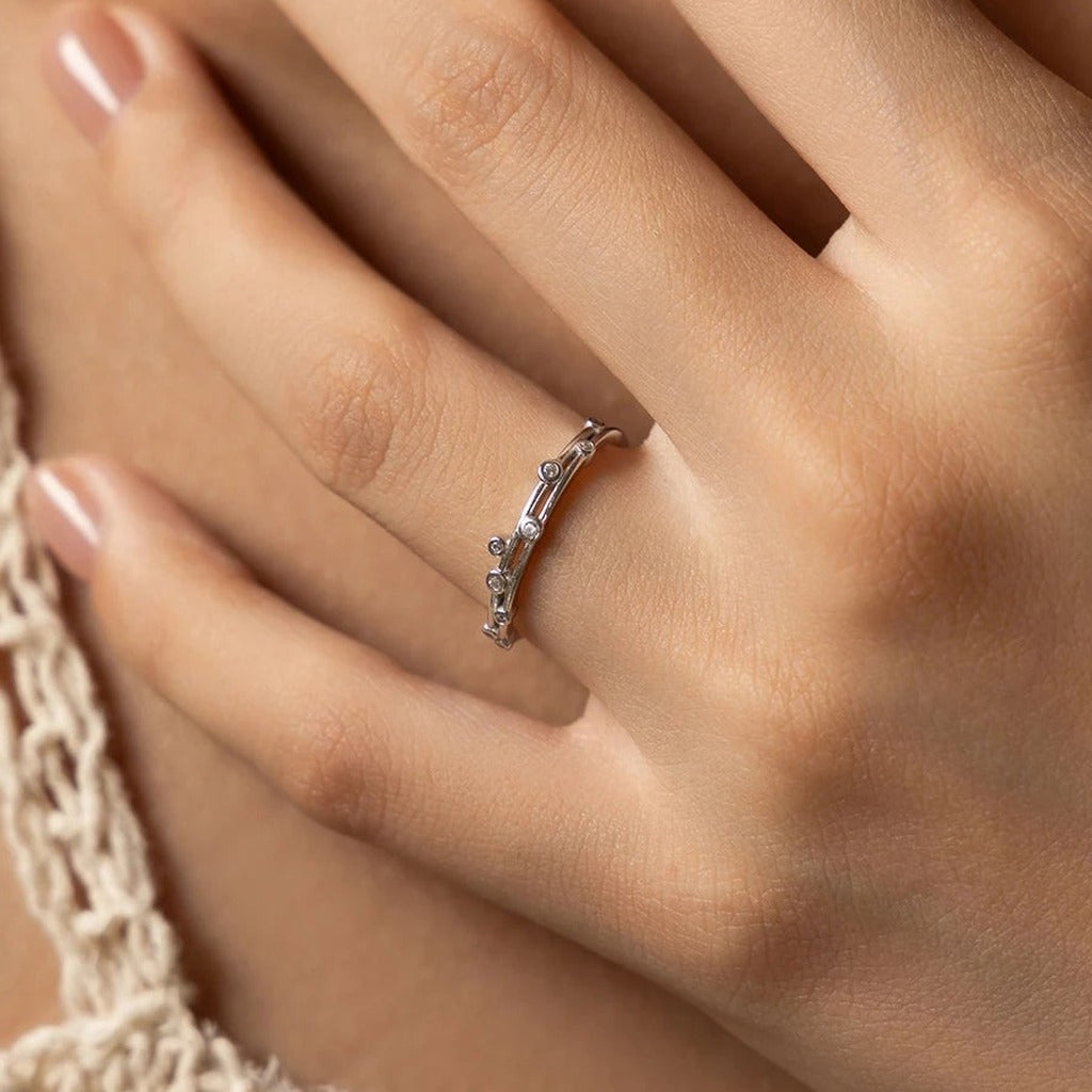 Bague Deux Orbites portée au doigt : le double anneau et ses petites pierres rondes