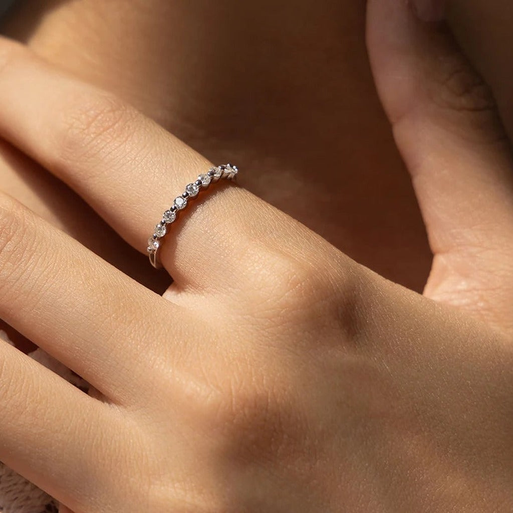 Bague Pointillés portée au doigt : la ligne de petites pierres espacées sur l'anneau fin