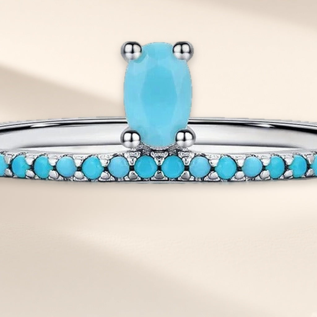 Bague Ruban d'Azur en gros plan : la pierre ovale turquoise et le rang de petites pierres sous elle