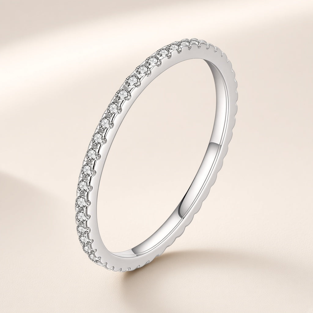 Bague Semis argent 925, modèle pierres incolores : un rang de petits zirconiums cubiques ronds serrés le long d'un anneau très fin, sur fond crème