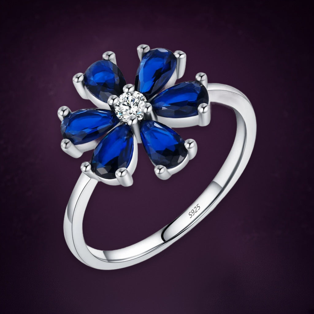 Bague Bleuet vue de trois quarts : six gouttes bleu roi en fleur autour d'une petite pierre claire