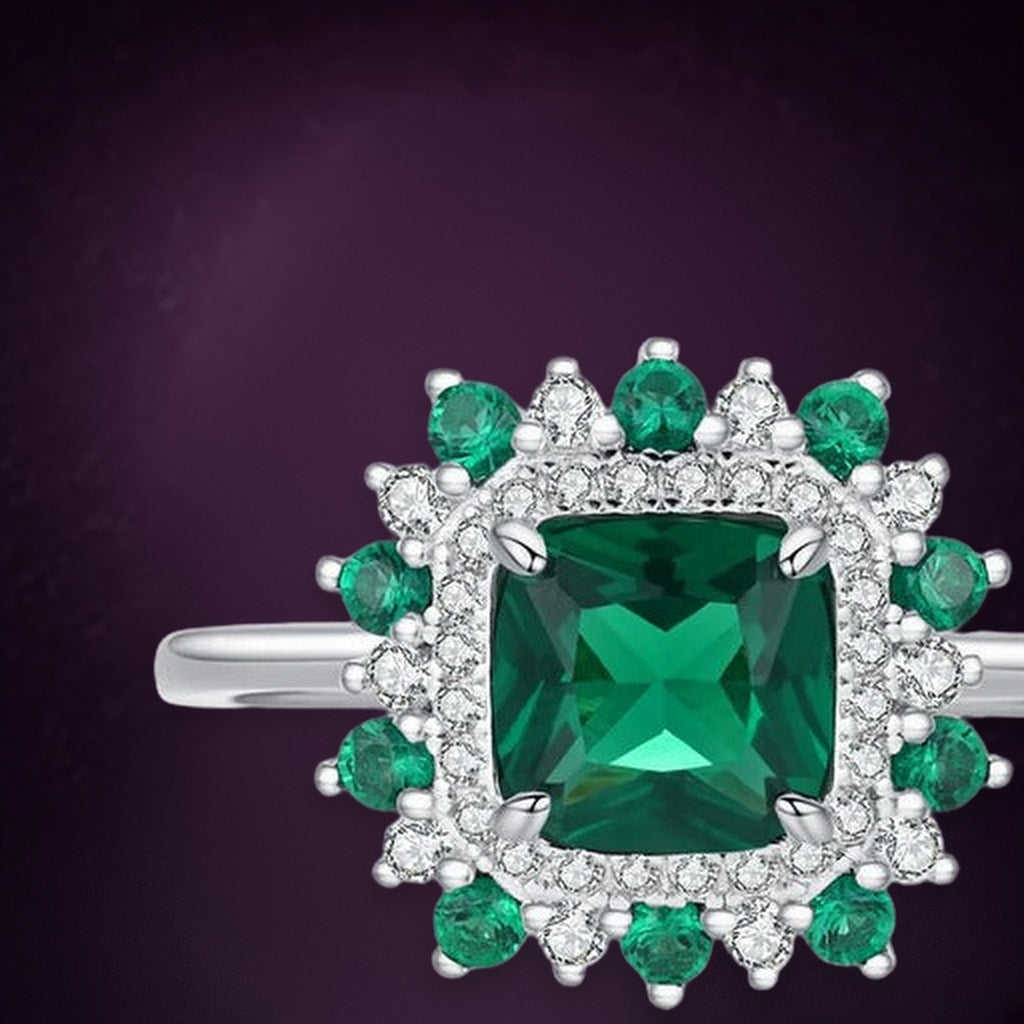 Bague Fleur de Mousse en gros plan : pierre carrée verte, halo de pierres claires et corolle de pierres vertes