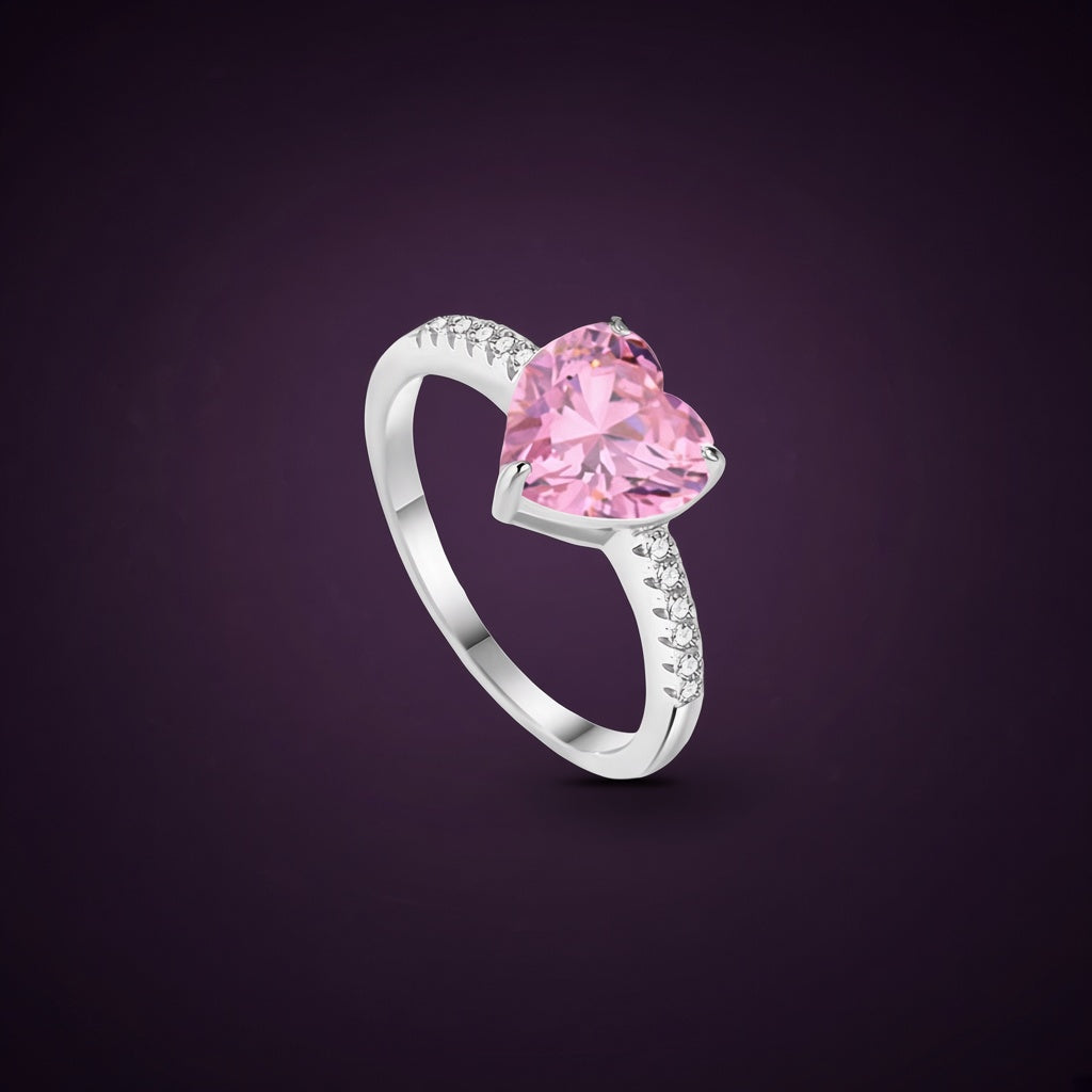 Bague Magnolia argent 925, grand cœur rose en zirconium cubique tenu haut par des griffes, petites pierres claires sur l'anneau, sur fond aubergine