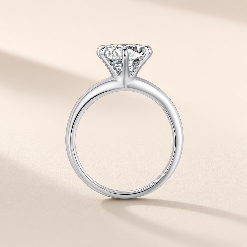 Bague Phare argent 925, modèle 8 mm : moissanite synthétique ronde et incolore tenue haut par six griffes, anneau lisse, sur fond crème