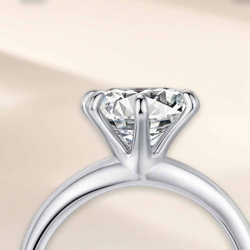Bague Phare en gros plan : grosse pierre ronde claire tenue haut par six griffes