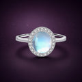 Bague Halo Lunaire argent 925, cabochon ovale d'imitation façon pierre de lune, laiteux aux reflets bleutés, dans un halo de zirconiums cubiques