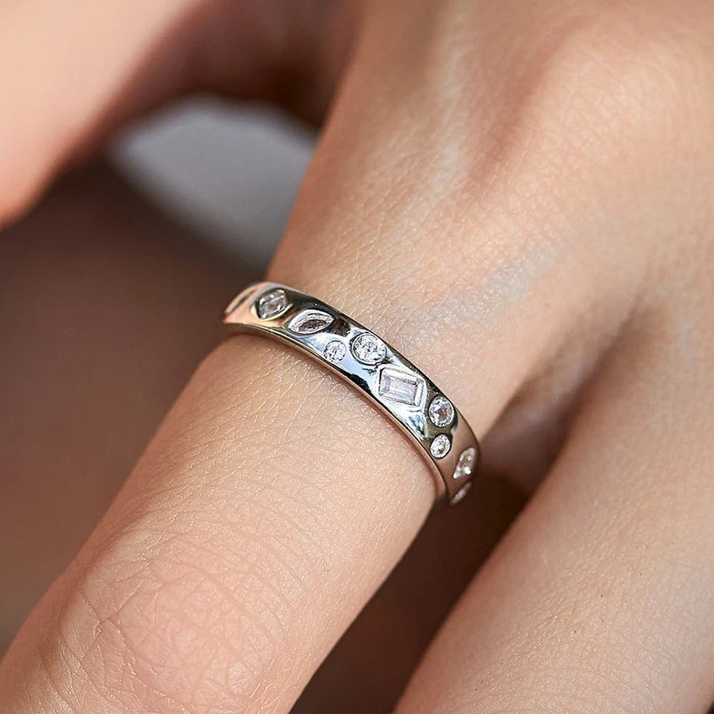 Bague Mosaïque portée au doigt : l'anneau large semé de petites pierres claires