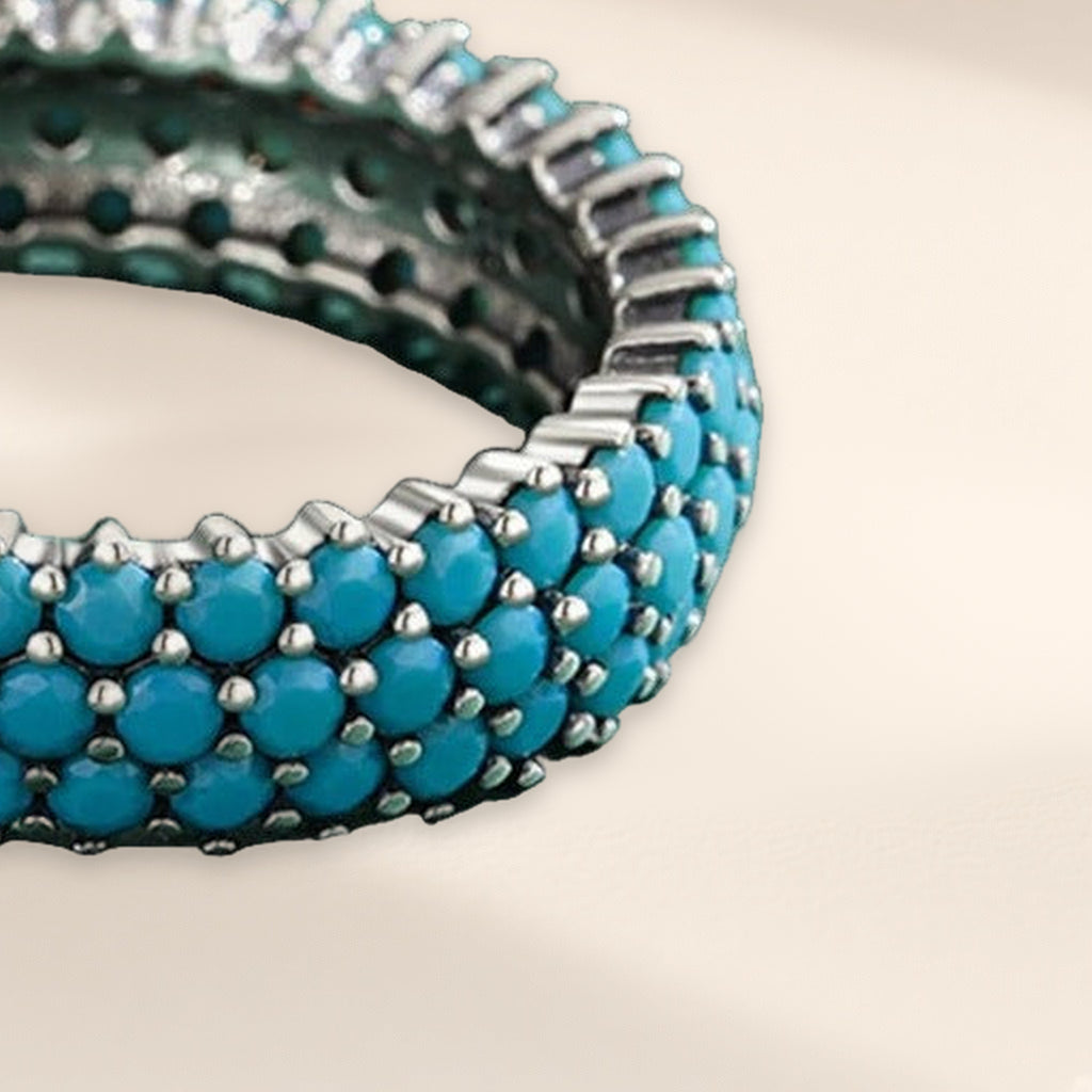 Bague Céleste en gros plan : les rangs de pierres turquoise et leurs griffes