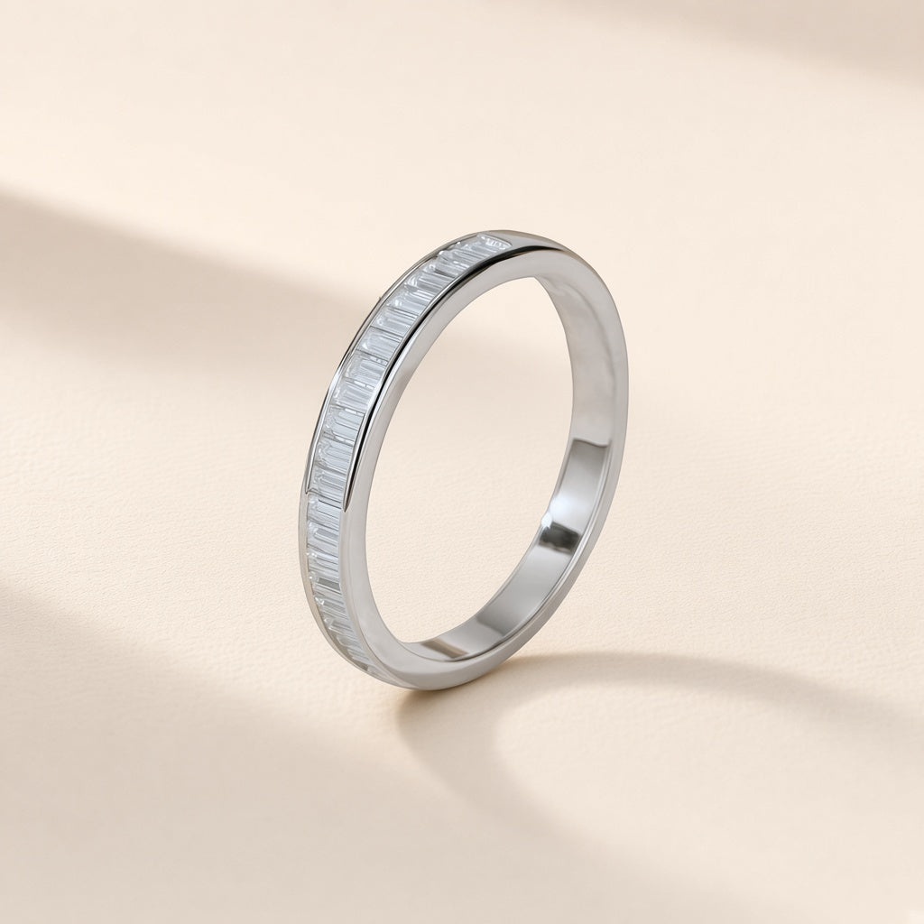 Bague Persienne argent 925, rangée de petites moissanites synthétiques rectangulaires entre deux bords de métal lisses, sur fond crème