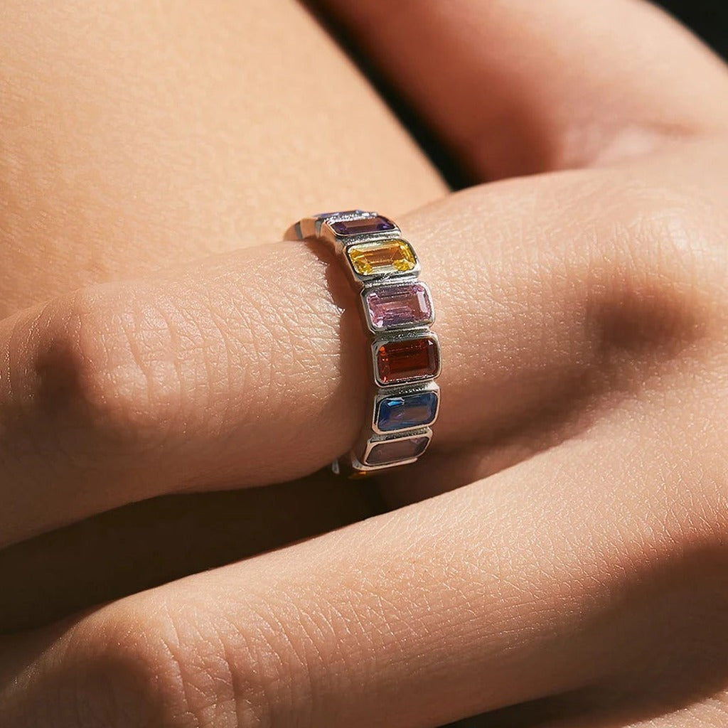 Bague Palette portée au doigt : pierres rectangulaires jaune, rouge, rose et bleue alignées