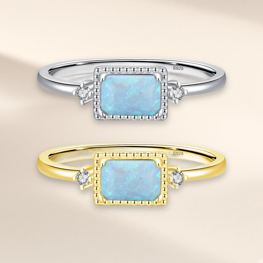 Bague Estampe, les deux finitions : argentée et dorée, pierre rectangulaire bleu pâle dans un cadre perlé