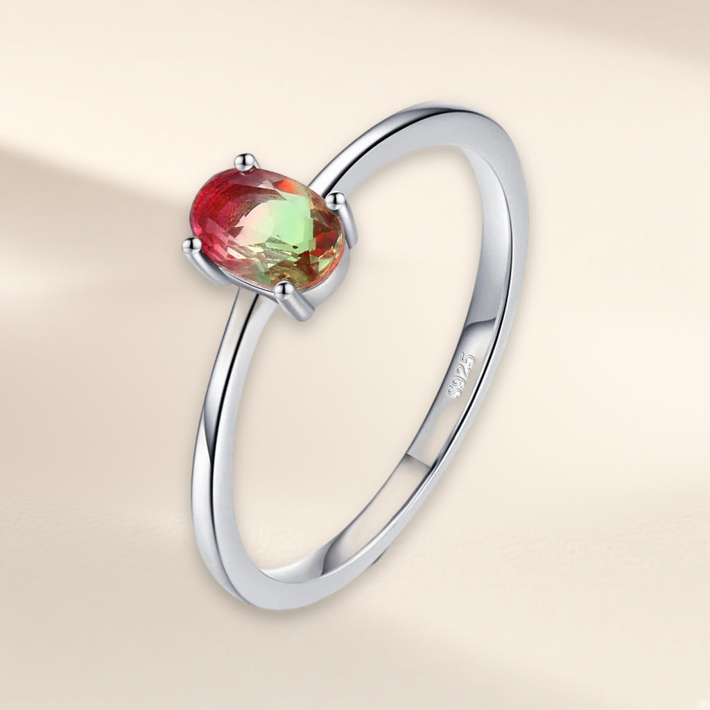Bague Arrière-Saison vue de trois quarts : pierre ovale rouge et verte à quatre griffes sur l'anneau fin