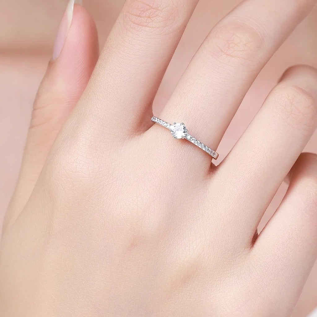 Bague Clarté portée au doigt : la pierre ronde et l'anneau serti vus de dessus