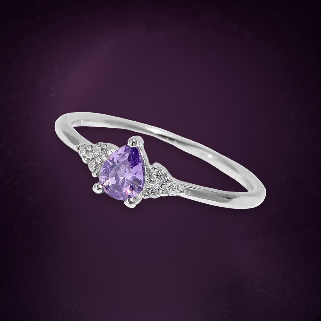 Bague Glycine argent 925, zirconium cubique violet taillé en goutte entre deux petits bouquets de pierres claires, sur fond aubergine