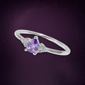 Bague Glycine argent 925, zirconium cubique violet taillé en goutte entre deux petits bouquets de pierres claires, sur fond aubergine