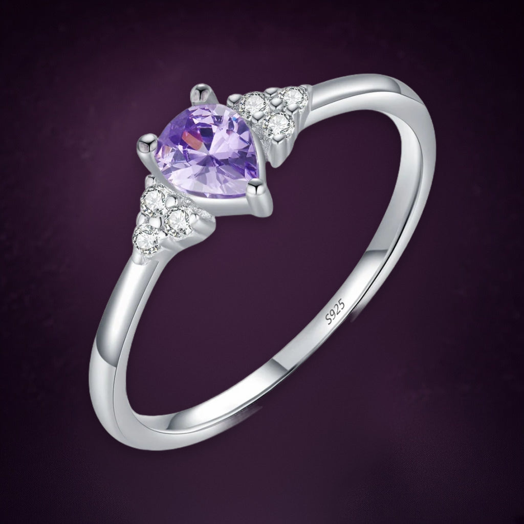 Bague Glycine en gros plan : goutte violette entre deux petits bouquets de pierres claires