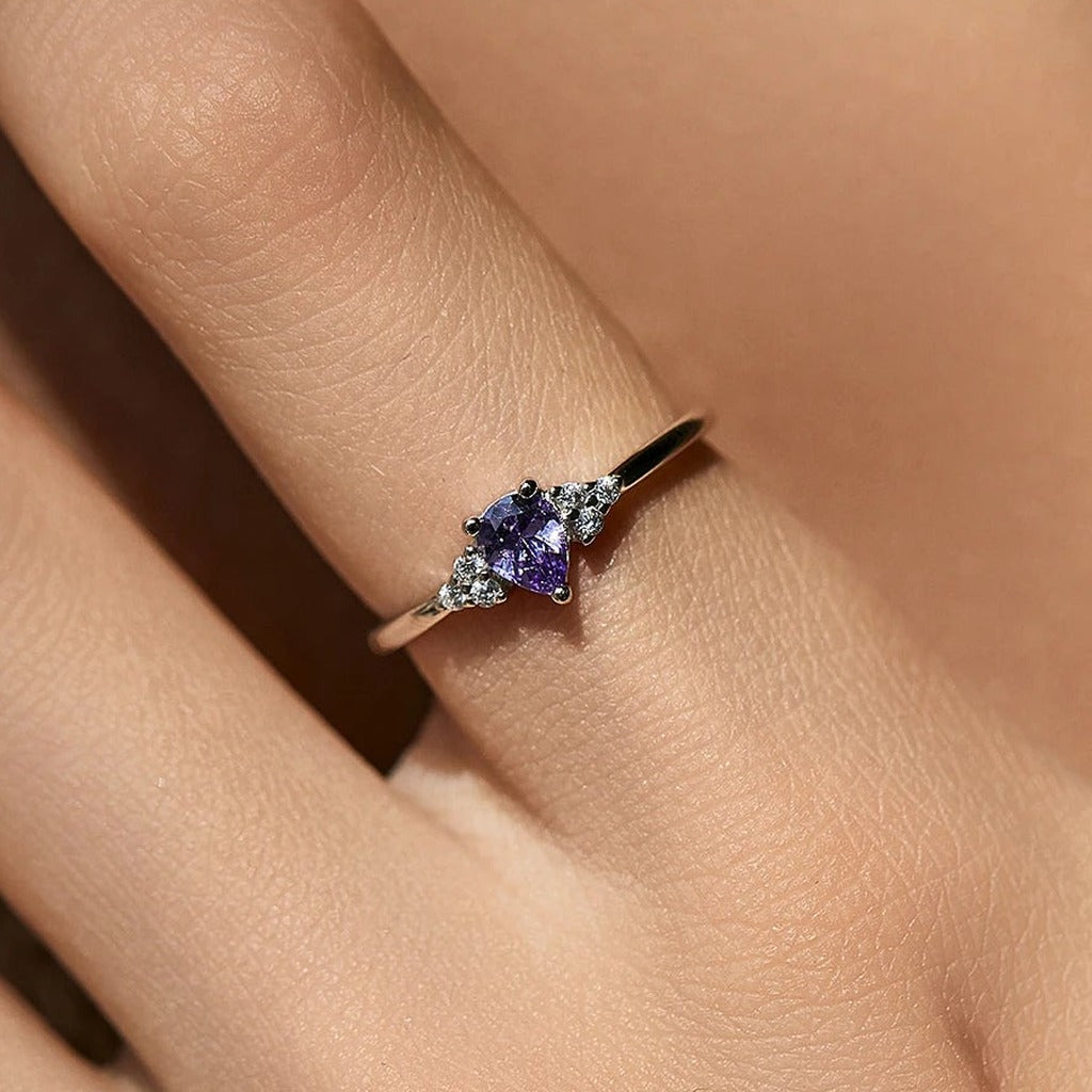 Bague Glycine portée au doigt : la goutte violette au centre de l'anneau fin