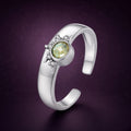 Bague soleil « Éclipse » ouverte en argent 925 : anneau large, soleil en relief serti d'un zirconium cubique jaune-vert, sur fond aubergine