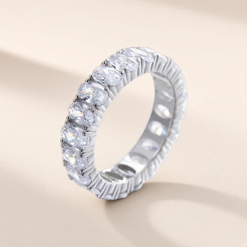Bague Farandole argent 925, tour complet de zirconiums cubiques ovales incolores sertis côte à côte, sur fond crème