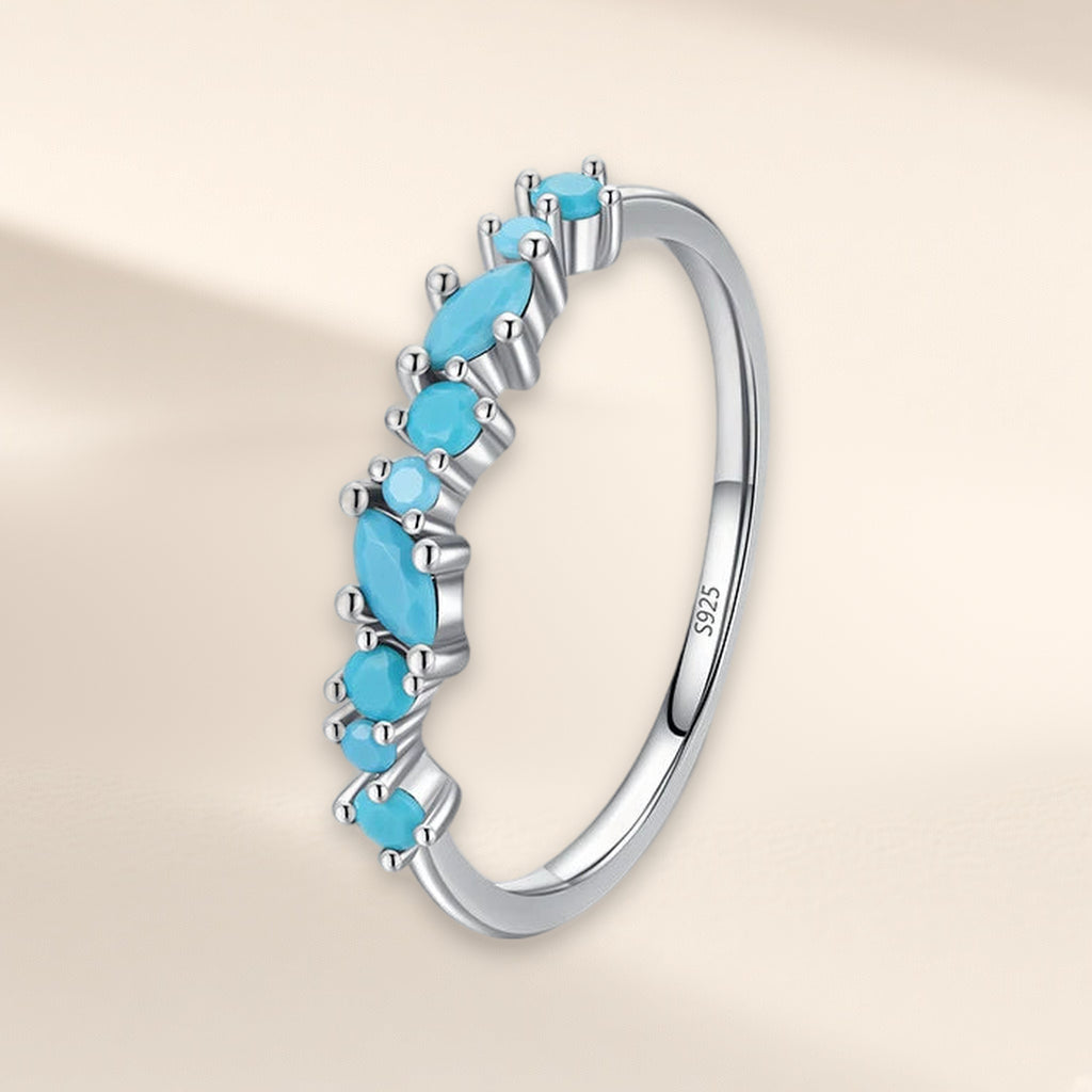 Bague Ressac vue de biais : ligne ondulée de petites pierres turquoise rondes et navette