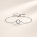 Bracelet Orbite argent 925, cercle ouvert serti de moissanites synthétiques sur chaîne fine, sur fond crème