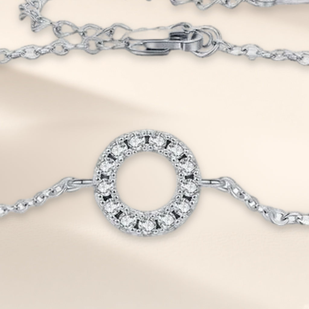 Bracelet Orbite en gros plan : cercle ouvert serti de petites pierres claires sur la chaîne fine