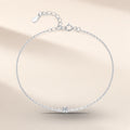 Bracelet Étoile du Berger argent 925, modèle 3 mm : une moissanite synthétique ronde tenue par quatre griffes au milieu d'une chaîne fine, rallonge au fermoir, sur fond crème