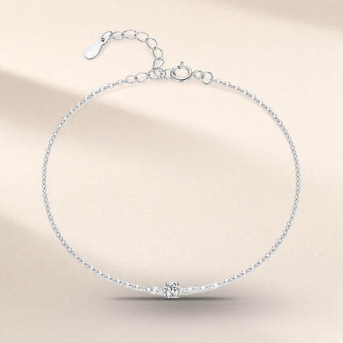 Bracelet Étoile du Berger argent 925, modèle 3 mm : une moissanite synthétique ronde tenue par quatre griffes au milieu d'une chaîne fine, rallonge au fermoir, sur fond crème