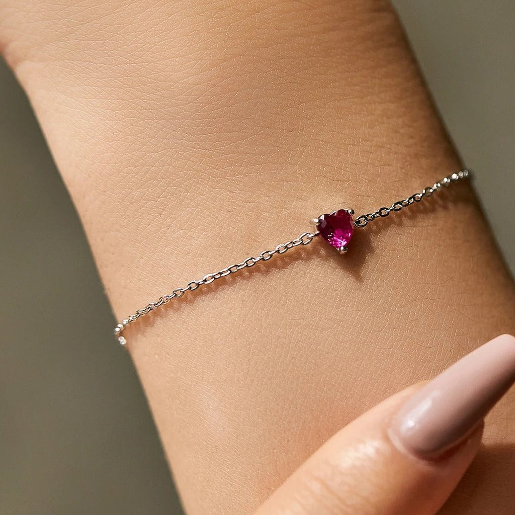 Bracelet Cœur de Pivoine porté au poignet : le petit cœur rose fuchsia sur la chaîne fine