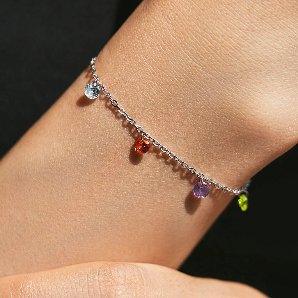 Bracelet Bulles de Savon porté au poignet : pierres bleue, rouge, orange, violette et verte le long de la chaîne
