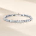Bracelet tennis Frimas argent 925, modèle 3 mm : moissanites synthétiques rondes et incolores tenues par des griffes sur tout le tour, sur fond crème