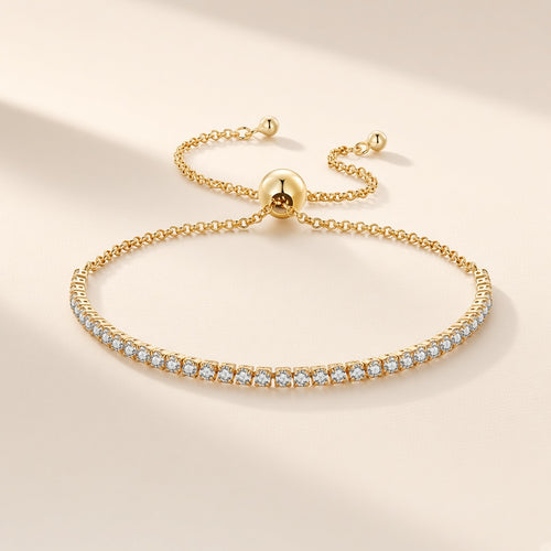 Bracelet Rivière de Lumière, finition dorée, ligne de zirconium cubique à fermoir coulissant réglable, sur fond crème