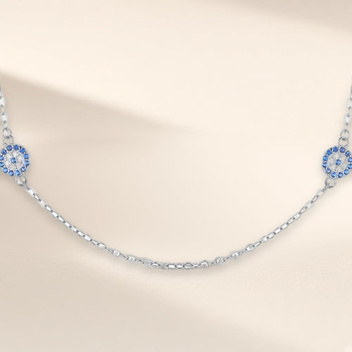 Collier Signe Bleu argenté vu de biais : médaillons ronds bleus et clairs espacés sur la chaîne fine