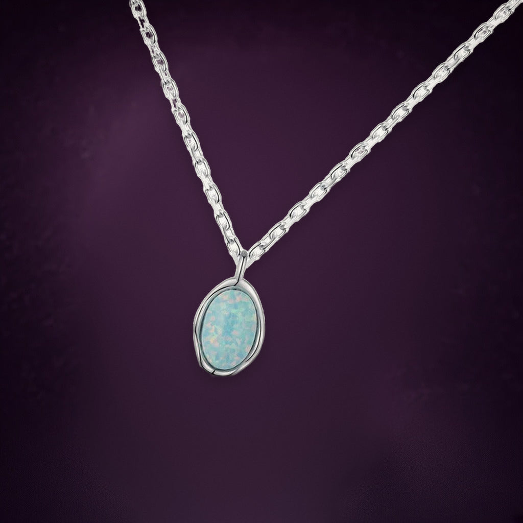 Collier Lune d'Écume vu de biais : pendentif ovale bleu pâle irisé dans un contour en vague