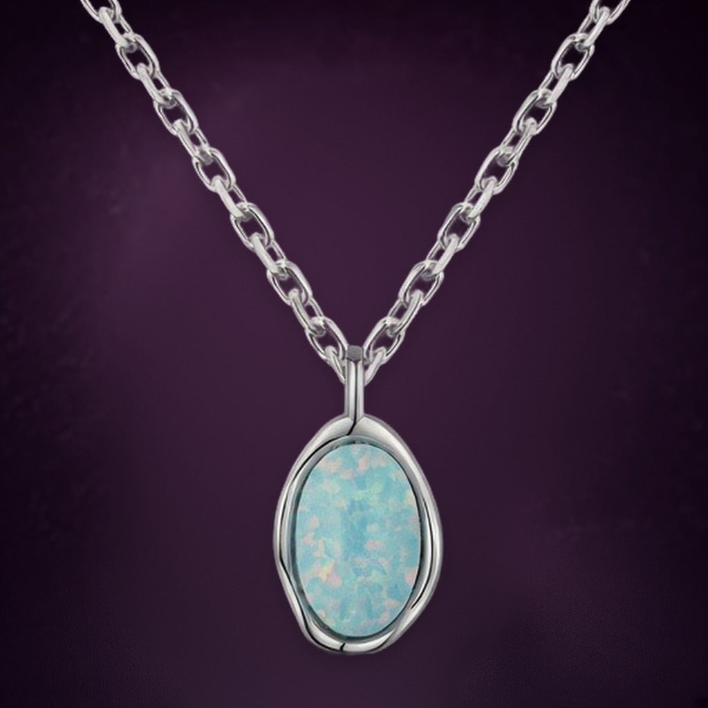 Collier Lune d'Écume en gros plan : les reflets du pendentif ovale bleu pâle et son contour en vague