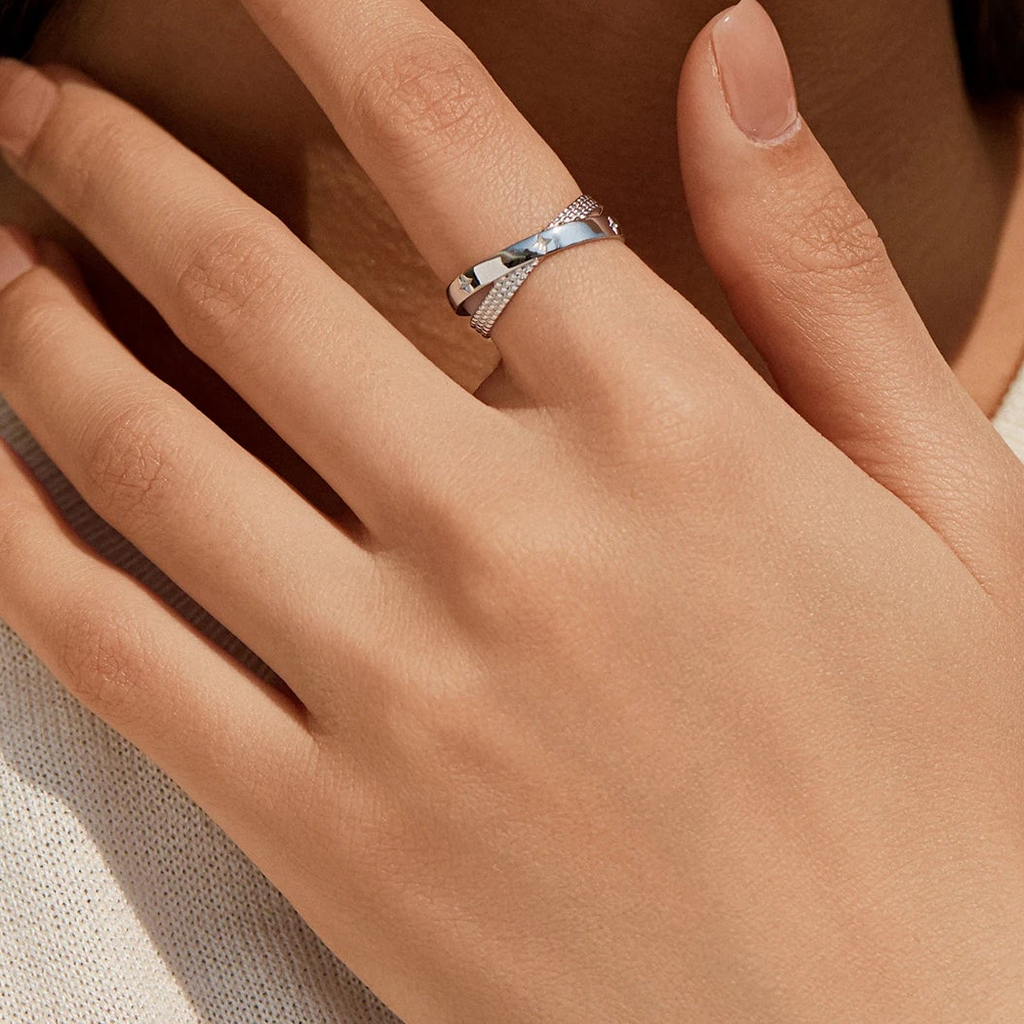 Bague Constellation argent 925 portée à l'annulaire, motif croisé étoilé