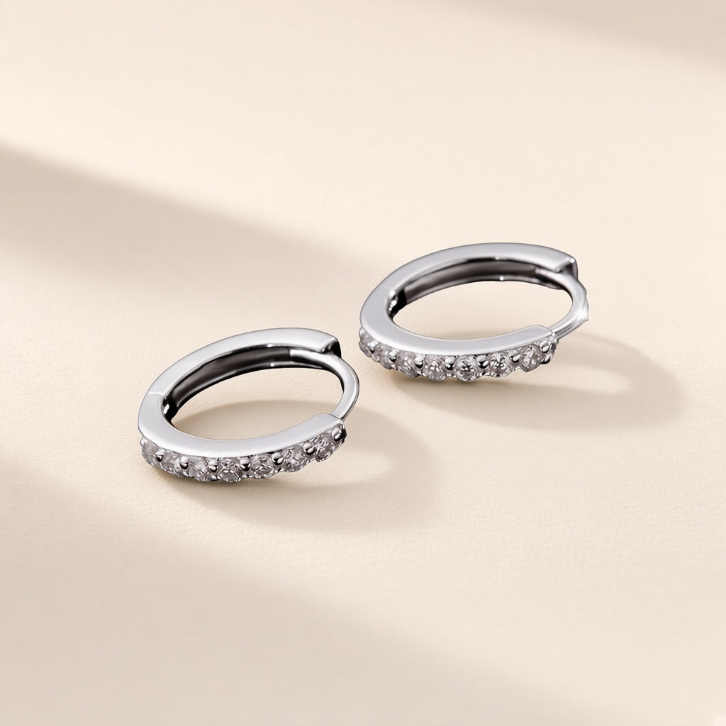 Créoles Liseré argent 925 à charnière, un rang de petites moissanites synthétiques sur la face visible de chaque créole, sur fond crème