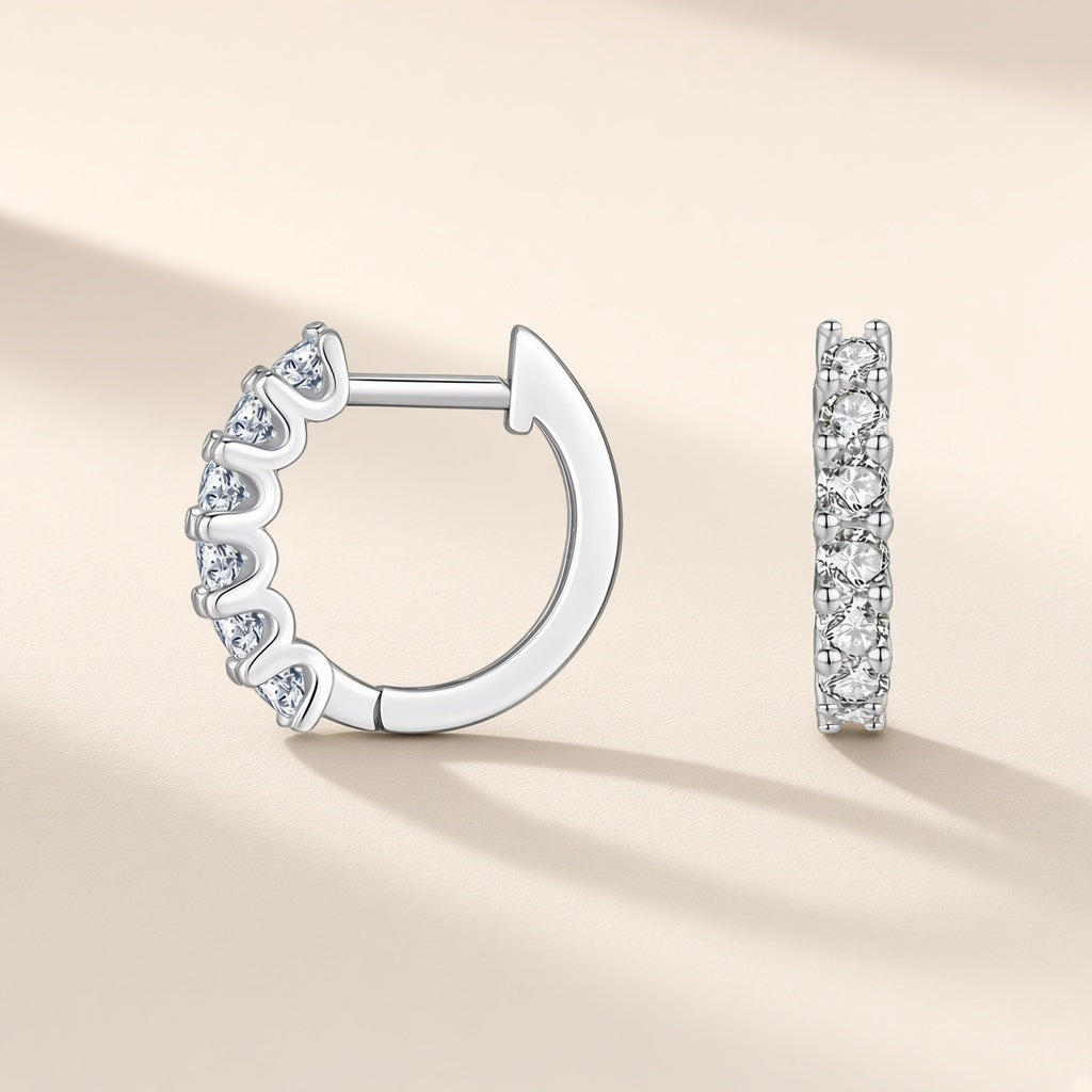 Petites créoles Pléiade argent 925, rang de moissanites synthétiques incolores sur la face visible, sur fond crème
