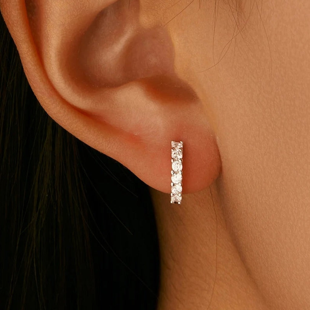 Créoles Pléiade portées à l'oreille : la petite créole sertie près du lobe