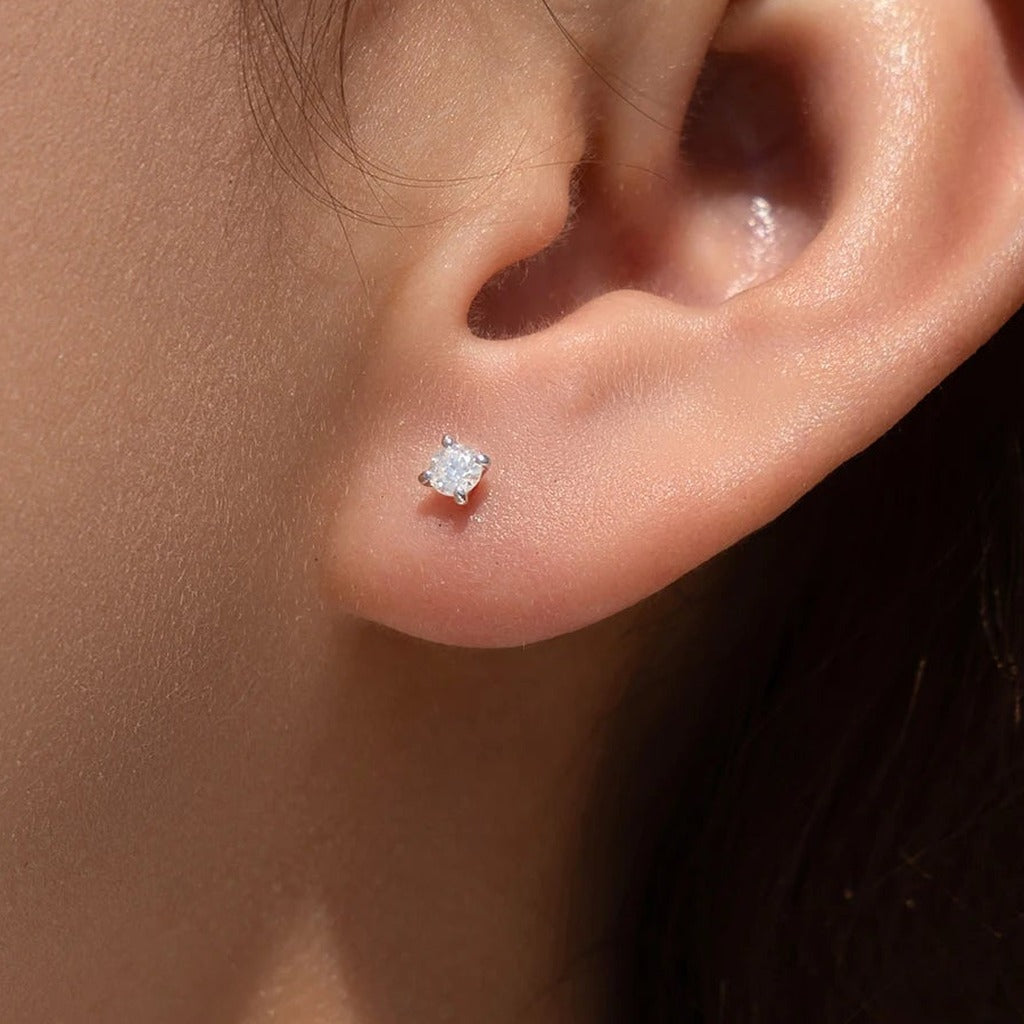 Puces Veilleuse portées à l'oreille : la petite pierre ronde claire sur le lobe