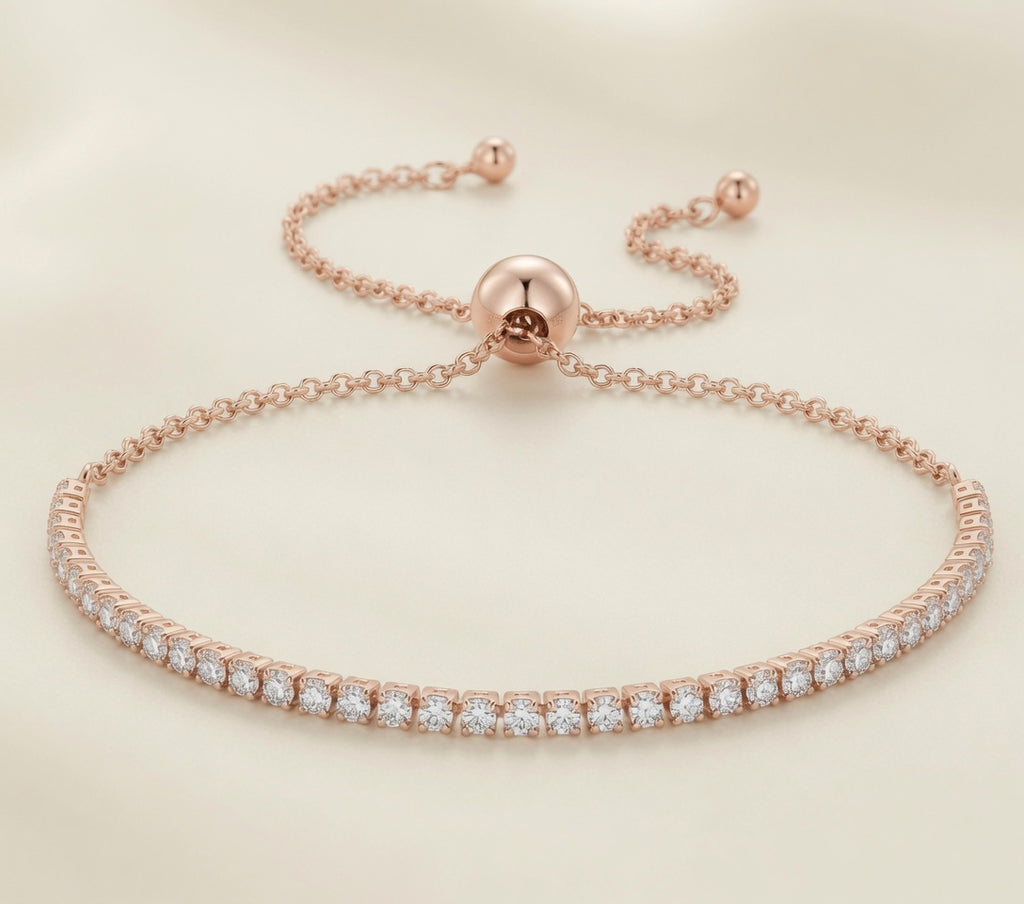 Bracelet Rivière de Lumière plaqué or rose, ligne de zirconium et fermoir bolo réglable, sur fond crème