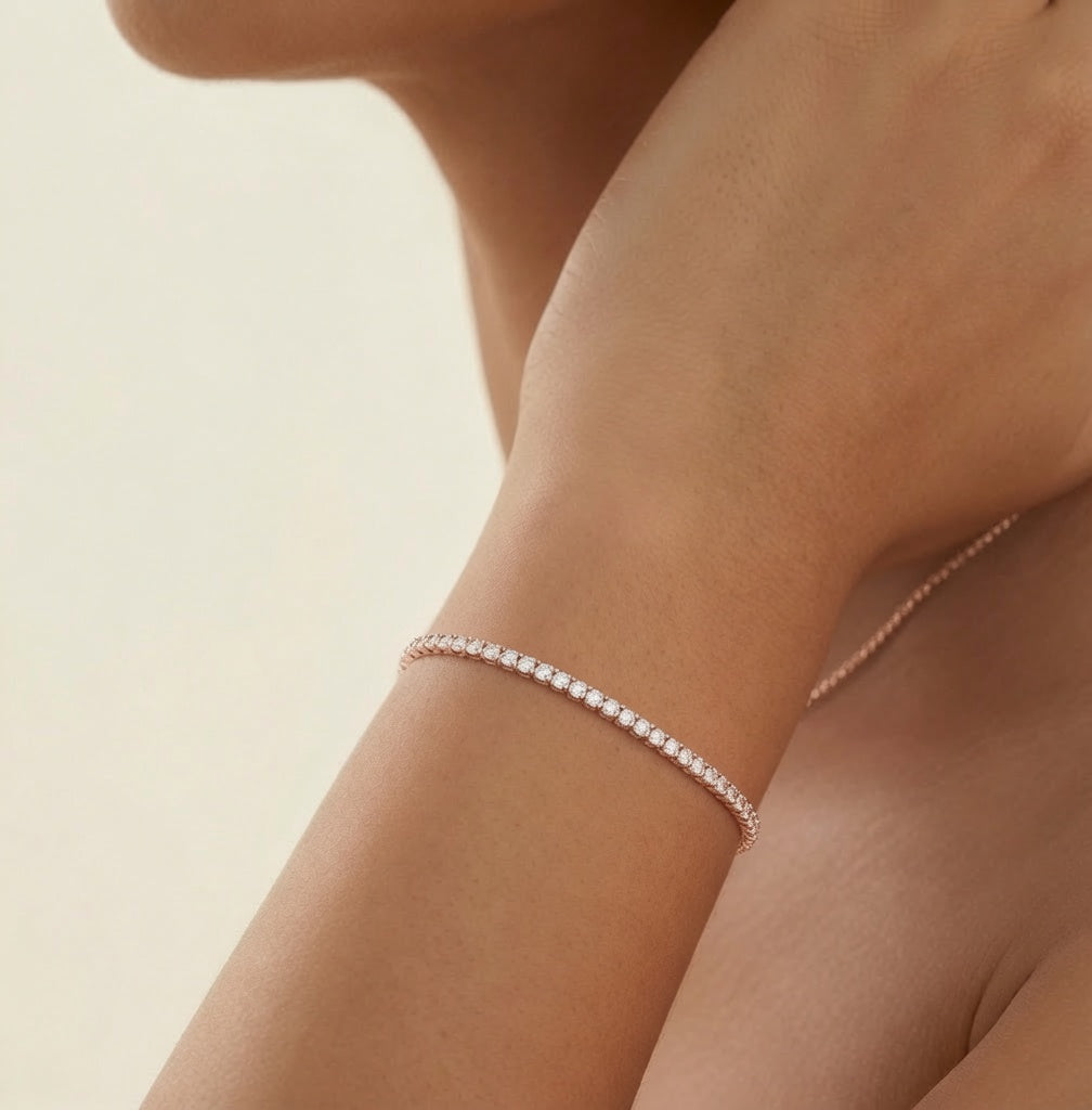 Bracelet Rivière de Lumière plaqué or rose porté au poignet, ligne de zirconium, sur fond crème